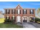 Two-story brick home with black shutters and a manicured front lawn offers classic charm at 9066 Bob Jackson Dr, Jonesboro, GA 30238
