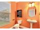 Bright bathroom with pedestal sink, window, and cabinet at 275 Blue Pointe Ct, Suwanee, GA 30024