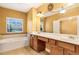 Bright bathroom featuring a soaking tub, and a vanity with double sinks at 275 Blue Pointe Ct, Suwanee, GA 30024