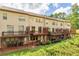 Back of townhomes reveals multiple decks with stairs down to the ground level and beautiful lawn at 275 Blue Pointe Ct, Suwanee, GA 30024