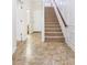 Foyer with tile floor and a staircase with wood handrail and access to a bathroom and closet at 275 Blue Pointe Ct, Suwanee, GA 30024