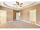 A spacious main bedroom with trey ceiling, ceiling fan, neutral walls and carpet, and doorways to bathroom, stairs, and closets at 275 Blue Pointe Ct, Suwanee, GA 30024