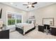 Comfortable bedroom with large window, black metal bed, and dedicated desk area, flooded with natural light at 3786 Alstead Manor Way, Suwanee, GA 30024