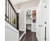 Hallway featuring dark hardwood floors and convenient closet organization, adjacent to the staircase at 3786 Alstead Manor Way, Suwanee, GA 30024