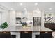 Well-lit kitchen boasts stainless steel appliances, a large island, and white cabinets for a clean, modern look at 3786 Alstead Manor Way, Suwanee, GA 30024