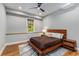 A cozy bedroom featuring a hardwood platform bed, a ceiling fan, and a sunny window at 504 S Westminster Ne Way, Atlanta, GA 30307