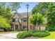 Beautiful front yard with a light post, manicured bushes, large trees, and a charming two-story brick home at 504 S Westminster Ne Way, Atlanta, GA 30307