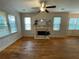 Bright living room with a fireplace, hardwood floors, large windows, and a ceiling fan for a comfortable ambiance at 937 Capitol View Nw Ave, Atlanta, GA 30318