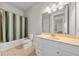 Bathroom features a shower with striped curtain and a light-colored sink with tile floors at 132 Shellbark Dr, Mcdonough, GA 30252