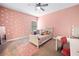 This bedroom has pink walls and polka dots and a ceiling fan with carpet at 132 Shellbark Dr, Mcdonough, GA 30252