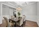 Dining area boasts coffered ceilings, wainscoting, hardwood floors, and stylish chandelier at 132 Shellbark Dr, Mcdonough, GA 30252
