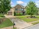 Stunning brick home featuring a manicured lawn, a two-car garage, and a long driveway for ample parking at 132 Shellbark Dr, Mcdonough, GA 30252