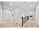 Bright hallway with carpet and wood railing offers access to the various rooms on the upper level at 132 Shellbark Dr, Mcdonough, GA 30252