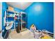 This is a laundry room with a stackable washer and dryer and shelves and blue walls at 132 Shellbark Dr, Mcdonough, GA 30252