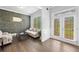 Cozy living room with wood accent wall, plush seating, and natural light from French doors at 132 Shellbark Dr, Mcdonough, GA 30252