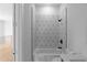 A white bathroom with a white geometric tile surround over the tub and shower at 1610 Niskey Lake Rd, Atlanta, GA 30331