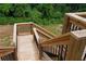 Wooden deck shows stairs with black railings, green shrubbery and grass below at 1610 Niskey Lake Rd, Atlanta, GA 30331