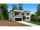 Modern two-story home with white exterior, black trim, balcony, and a driveway leading to an attached garage at 1610 Niskey Lake Rd, Atlanta, GA 30331