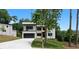 Contemporary home featuring a clean white facade, a balcony, a black garage door, and a neatly landscaped front yard at 1610 Niskey Lake Rd, Atlanta, GA 30331
