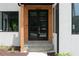 Modern front door with glass panels, wood accents, and a stone walkway leading to the entrance of the home at 1610 Niskey Lake Rd, Atlanta, GA 30331