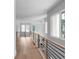 Upstairs hallway featuring sleek light-wood floors, modern railing, and multiple windows providing ample natural light at 1610 Niskey Lake Rd, Atlanta, GA 30331