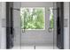 Stunning, frameless dual shower with dual rainfall showerheads and a view of trees at 1610 Niskey Lake Rd, Atlanta, GA 30331