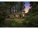 Charming single-story brick home featuring an attached carport and lush, mature landscaping at dusk at 2595 Woodhill Cir, Atlanta, GA 30344