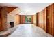 Spacious living room with wood paneling, a brick fireplace, and a large window showcasing the outdoors at 2595 Woodhill Cir, Atlanta, GA 30344