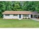 Charming brick home features a manicured lawn, updated windows, and a convenient carport at 5689 Woodland Dr, Acworth, GA 30102