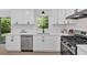 White kitchen boasts stainless appliances, sleek countertops, modern fixtures, and a window view at 5689 Woodland Dr, Acworth, GA 30102