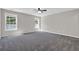 Spacious bedroom featuring plush gray carpet, neutral walls, and a ceiling fan for a comfortable and inviting atmosphere at 6645 Crest Wood Ln, Douglasville, GA 30135