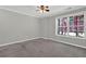 Serene bedroom with soft gray carpet, natural light from the window, and minimalist decor for relaxation at 6645 Crest Wood Ln, Douglasville, GA 30135