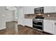 Kitchen showcasing stainless steel stove, oven, microwave, tile backsplash, and white cabinets at 6645 Crest Wood Ln, Douglasville, GA 30135
