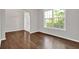 Bright living room with hardwood floors, large window, and neutral paint at 6645 Crest Wood Ln, Douglasville, GA 30135