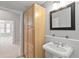 Bright bathroom featuring wooden storage cabinet, a pedestal sink, and a large mirror at 850 Piedmont Ne Ave # 3304, Atlanta, GA 30308