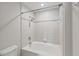 Clean white tiled bathtub and shower with decorative border and modern fixtures at 850 Piedmont Ne Ave # 3304, Atlanta, GA 30308