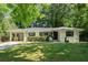 Charming ranch home featuring a spacious front yard, carport, and a classic white brick facade at 3180 Rehoboth Dr, Decatur, GA 30033