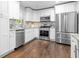 Bright kitchen features white cabinets, stainless steel appliances, granite countertops, and hardwood floors at 3180 Rehoboth Dr, Decatur, GA 30033