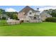 Expansive backyard with a wooden fence, deck, mature trees, and three car garage at 388 Golf Crest Dr, Acworth, GA 30101