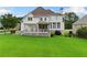 Expansive backyard featuring a large lawn, deck, covered porch, and mature trees at 388 Golf Crest Dr, Acworth, GA 30101