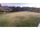 Expansive grassy backyard featuring a wooden fence, mature trees, and playhouse at 388 Golf Crest Dr, Acworth, GA 30101