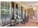Charming brick front porch with rocking chairs, brick floor, and black shutters at 388 Golf Crest Dr, Acworth, GA 30101