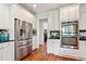 Modern kitchen with stainless steel refrigerator, double oven, and sleek white cabinetry at 388 Golf Crest Dr, Acworth, GA 30101