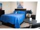 Cozy bedroom featuring a queen-sized bed with blue comforter and dark wood furniture at 7699 Cabrini Pl, Fairburn, GA 30213