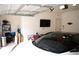 Well-organized two-car garage with a modern car, shelving, and a television at 7699 Cabrini Pl, Fairburn, GA 30213