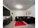 Spacious living room with a plush black sectional sofa and a large flat-screen TV at 7699 Cabrini Pl, Fairburn, GA 30213