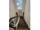 Staircase featuring wood steps, white risers, and a decorative light fixture at 7699 Cabrini Pl, Fairburn, GA 30213