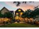 Beautiful backyard at dusk, featuring a well-manicured lawn, inviting fire pit, and outdoor dining space at 891 Paoli Se Ave, Atlanta, GA 30316