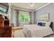 Bedroom with white bedding, dresser, and large windows; hardwood floors and ample natural light at 891 Paoli Se Ave, Atlanta, GA 30316