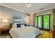 Comfortable bedroom with french doors leading to a cozy outdoor balcony; hardwood floors and ample natural light at 891 Paoli Se Ave, Atlanta, GA 30316